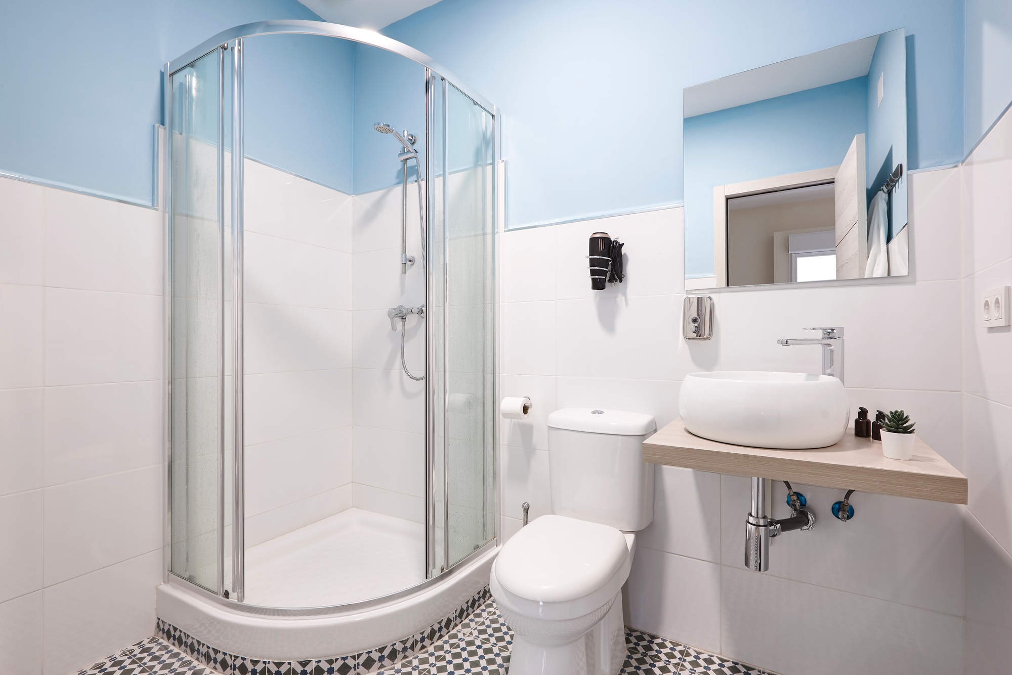 Bathroom with shower cabin, sink and basin. Modern apartment